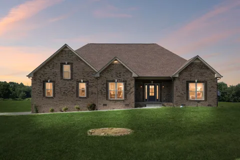a front view of a house with a garden and yard