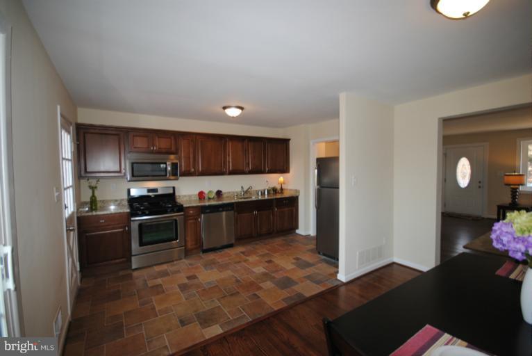 6206 Radecke Avenue Baltimore, MD 21206 - Photo 10 of 22 a kitchen with stainless steel appliances kitchen island granite countertop a refrigerator stove and sink