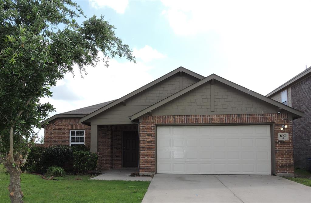 The property features a brick exterior with an attached garage and a concrete driveway
