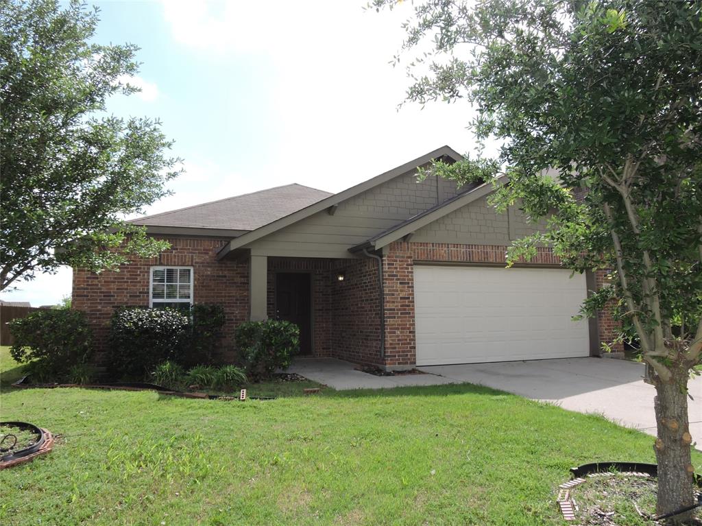 8050 Privet Street Forney, TX 75126 - Photo 2 of 24 The property features a brick exterior with a front-facing garage, a well-maintained lawn, and established trees providing natural shade