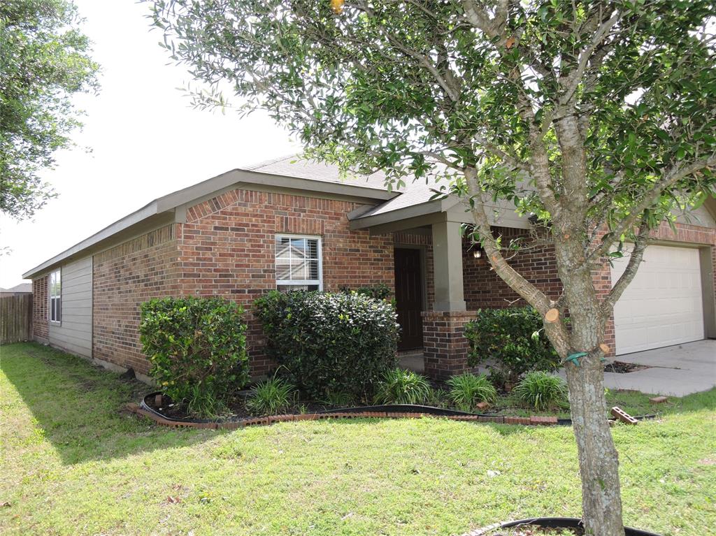 8050 Privet Street Forney, TX 75126 - Photo 23 of 24 The property features a brick exterior, a covered entryway with columns, an attached garage, a front yard with a lawn, and mature trees