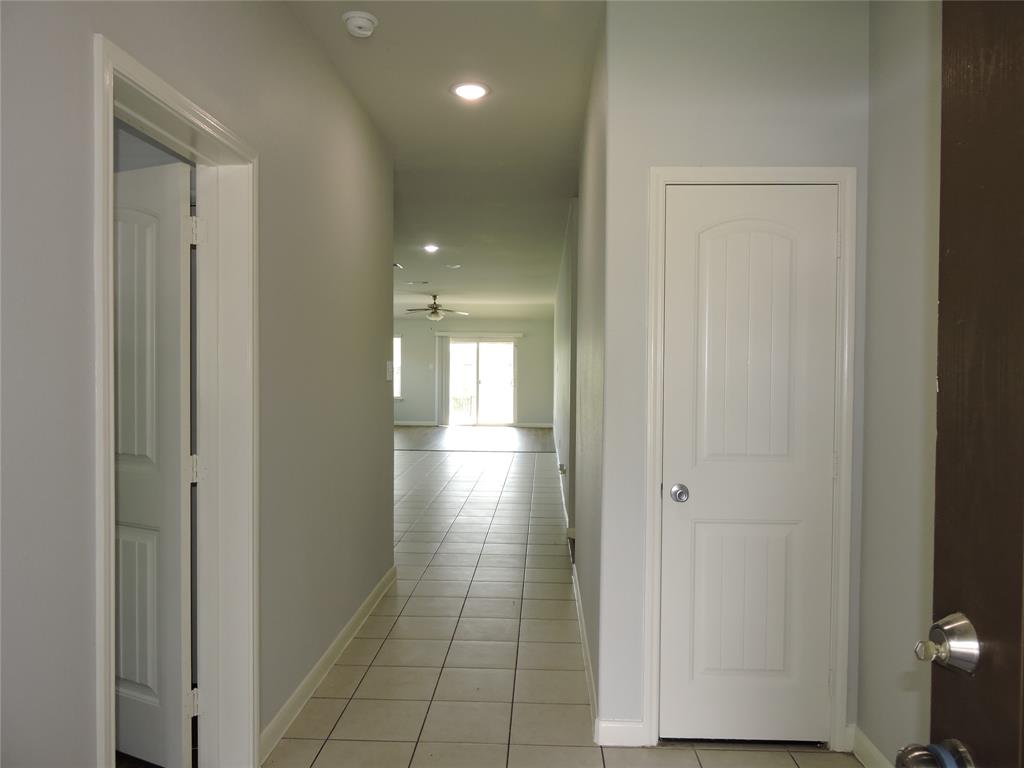 8050 Privet Street Forney, TX 75126 - Photo 3 of 24 Entryway featuring tiled flooring, a white paneled door, and recessed lighting, leading to an open living area with a ceiling fan and sliding glass doors
