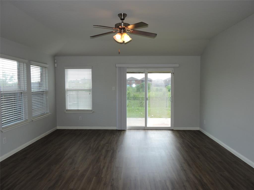 8050 Privet Street Forney, TX 75126 - Photo 9 of 24 This living area features rich dark flooring, light-colored walls, and a ceiling fan with integrated lighting