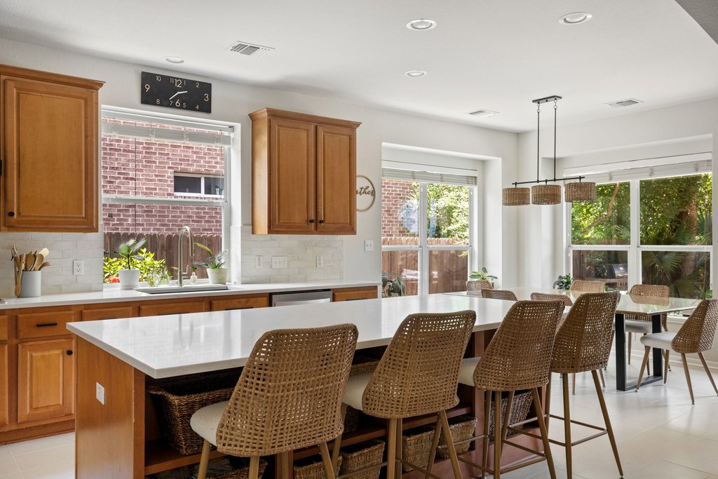 6704 Kiev Cove Austin, TX 78739 - Photo 16 of 37 A luminous kitchen island offers abundant counter space, complementing the well-lit dining area for seamless entertaining.
