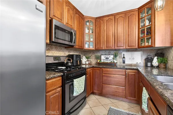 a kitchen with stainless steel appliances granite countertop a refrigerator and a sink