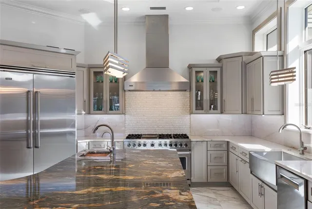 a kitchen with kitchen island granite countertop a stove and a sink