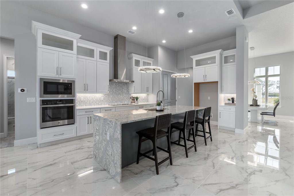 29 Coronado Road Flagler Beach, FL 32136 - Photo 16 of 81 a kitchen with stainless steel appliances kitchen island granite countertop a table and chairs in it