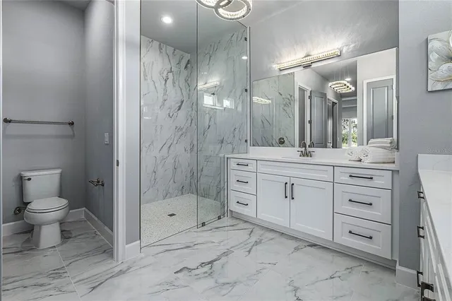 a large kitchen with stainless steel appliances a large counter top a stove and a refrigerator