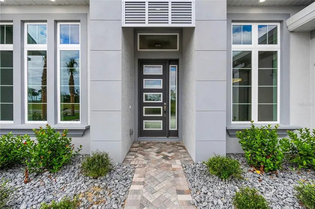 a living room with furniture a table and large windows