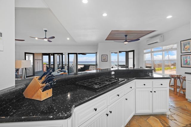 a kitchen with stainless steel appliances granite countertop a stove and white cabinets