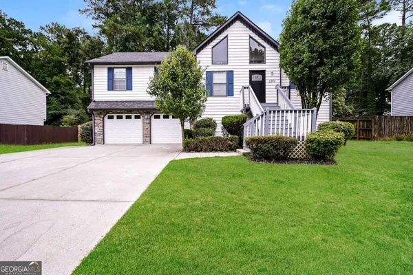 a front view of a house with a yard and trees