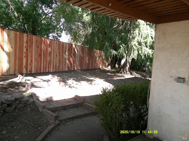 a view of a backyard with wooden fence
