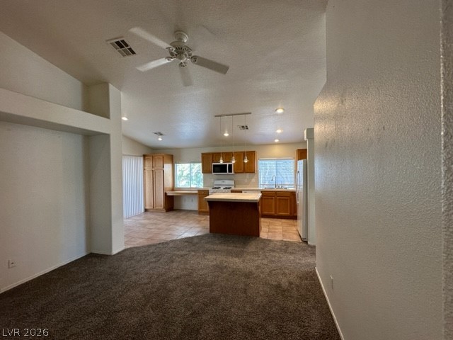 285 Spring Palms Street Henderson, NV 89012 - Photo 6 of 38 Kitchen featuring visible vents, freestanding refrigerator, gas range, light countertops, and a ceiling fan