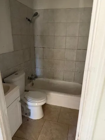 a white toilet sitting next to a bath tub