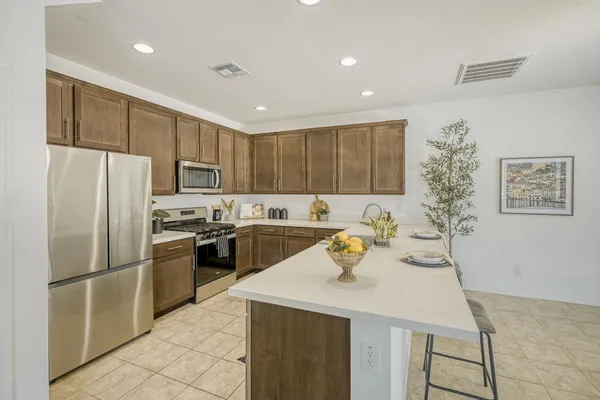 a kitchen with a refrigerator a stove top oven a sink and cabinets