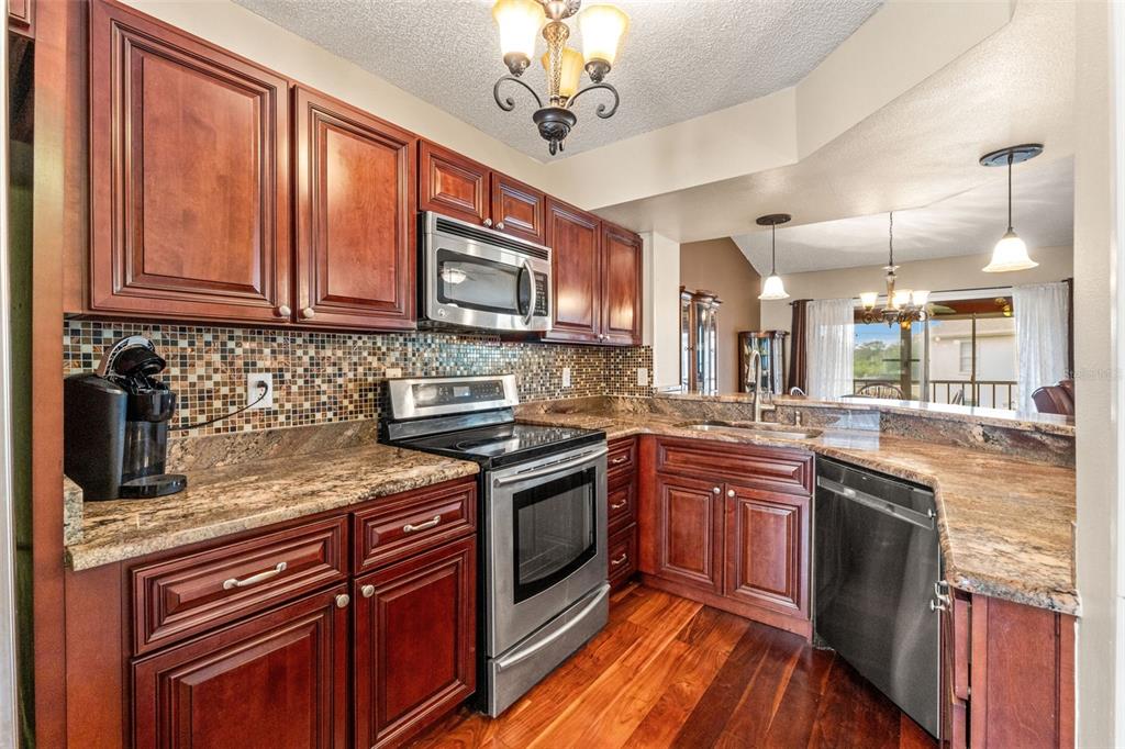 7828 Hardwick Drive, Unit 924 New Port Richey, FL 34653 - Photo 1 of 35 a kitchen with stainless steel appliances granite countertop a stove sink and cabinets