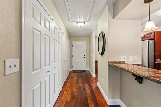 a view of a hallway with wooden floor and entryway