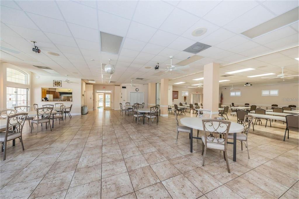 7828 Hardwick Drive, Unit 924 New Port Richey, FL 34653 - Photo 34 of 35 a room with lots of tables a table and chairs