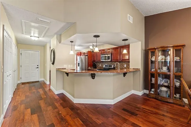 a view of a living room with kitchen appliances
