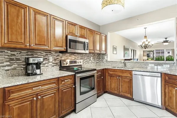 a kitchen with stainless steel appliances granite countertop a refrigerator and a sink
