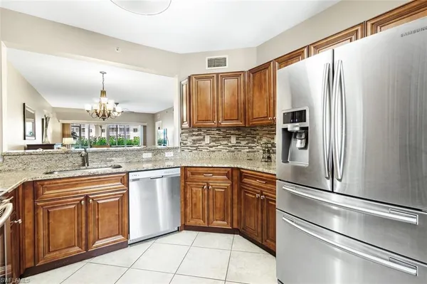 a kitchen with stainless steel appliances granite countertop a refrigerator a stove a sink and dishwasher
