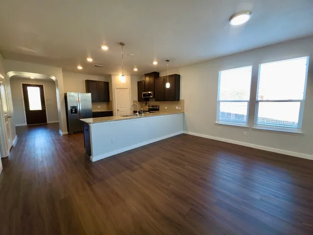 a view of a living room a kitchen and a wooden floor