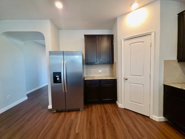 a kitchen with stainless steel appliances granite countertop a refrigerator and a sink