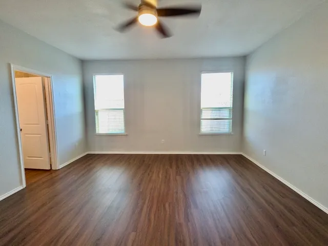 a kitchen with a sink wooden floor and black appliances
