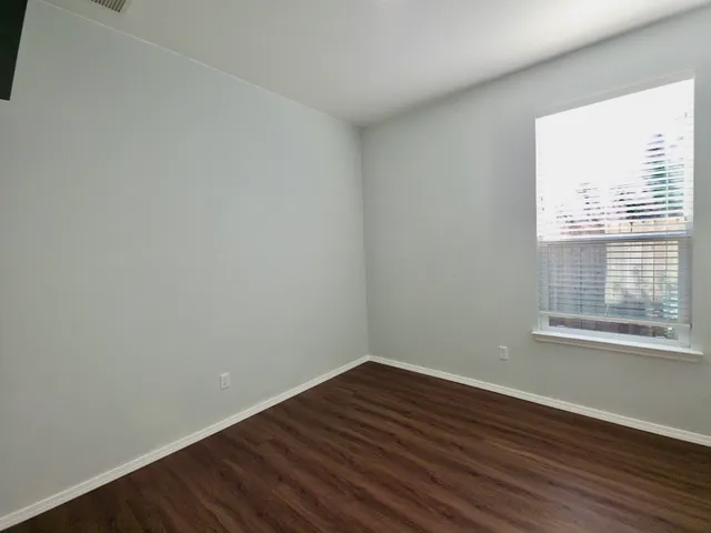 a view of an empty room with wooden floor