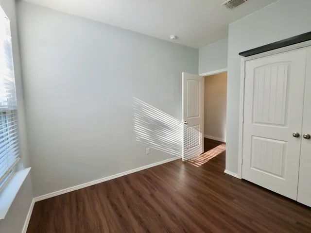 a view of an empty room with wooden floor