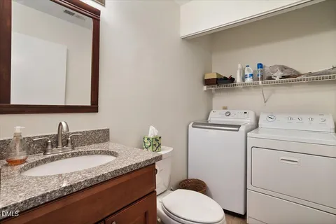 a bathroom with a granite countertop toilet sink and mirror
