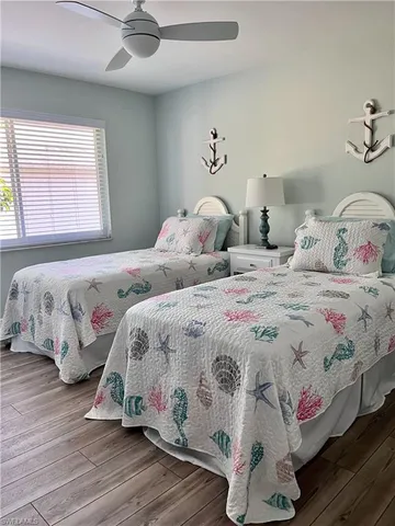 a bedroom with two beds and wooden floor