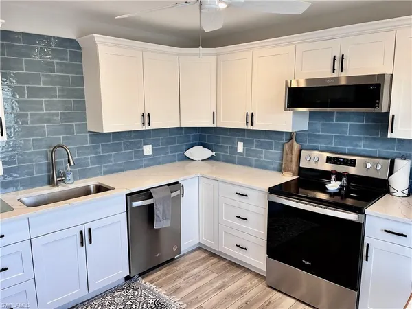 a kitchen with stainless steel appliances granite countertop a sink stove and cabinets