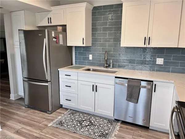 a kitchen with stainless steel appliances a refrigerator sink and cabinets