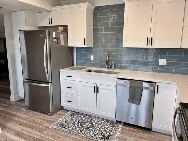 a kitchen with stainless steel appliances a refrigerator sink and cabinets