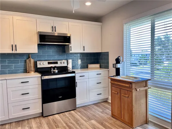 a kitchen with stainless steel appliances white cabinets and a stove top oven