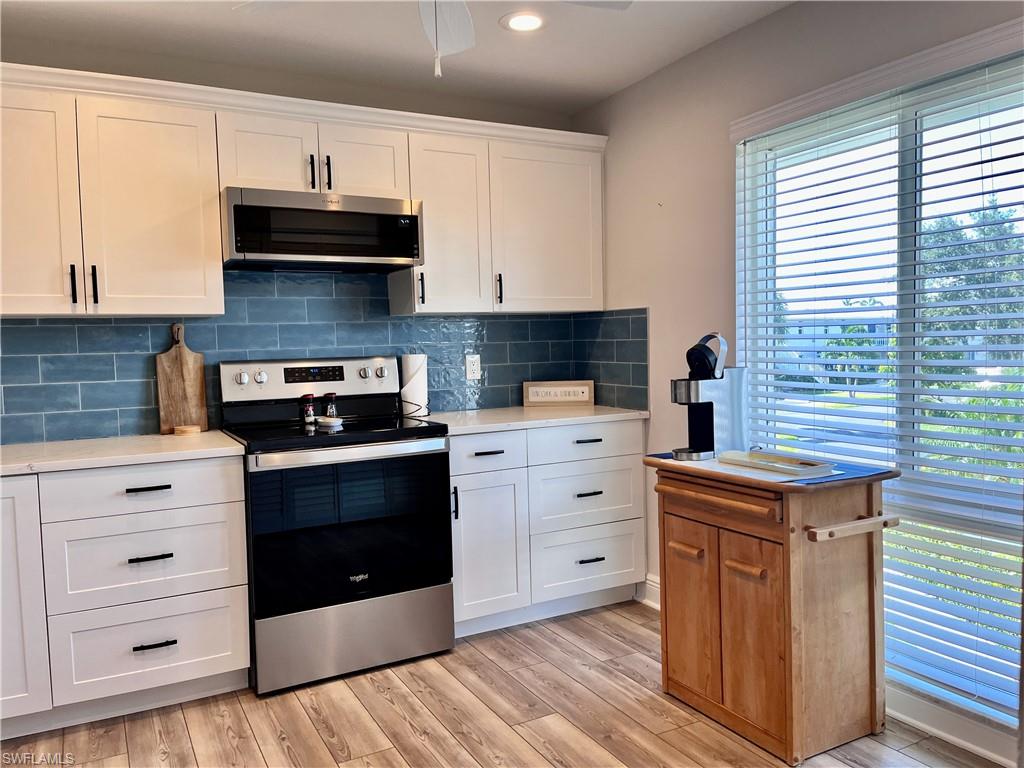 202 Peppermint Lane, Unit 2 Naples, FL 34112 - Photo 6 of 23 a kitchen with stainless steel appliances white cabinets and a stove top oven