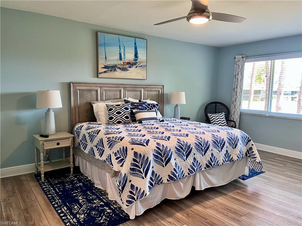 202 Peppermint Lane, Unit 2 Naples, FL 34112 - Photo 9 of 23 a bedroom with a bed and wooden floor