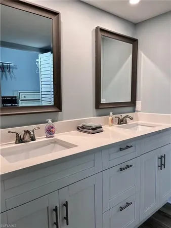 a bathroom with double sink and a mirror