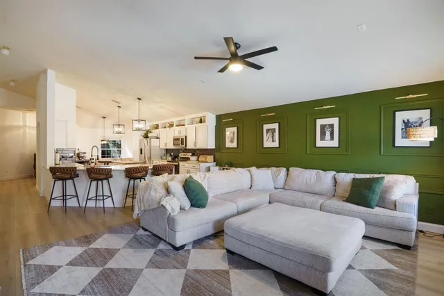 a living room with furniture and a view of kitchen
