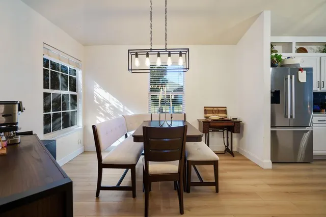 a dining room with furniture a chandelier and wooden floor