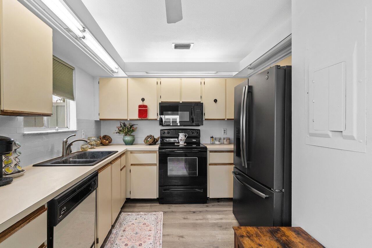 6199 Riverwalk Lane, Unit 6 Jupiter, FL 33458 - Photo 13 of 33 a kitchen with stainless steel appliances granite countertop a refrigerator and a sink