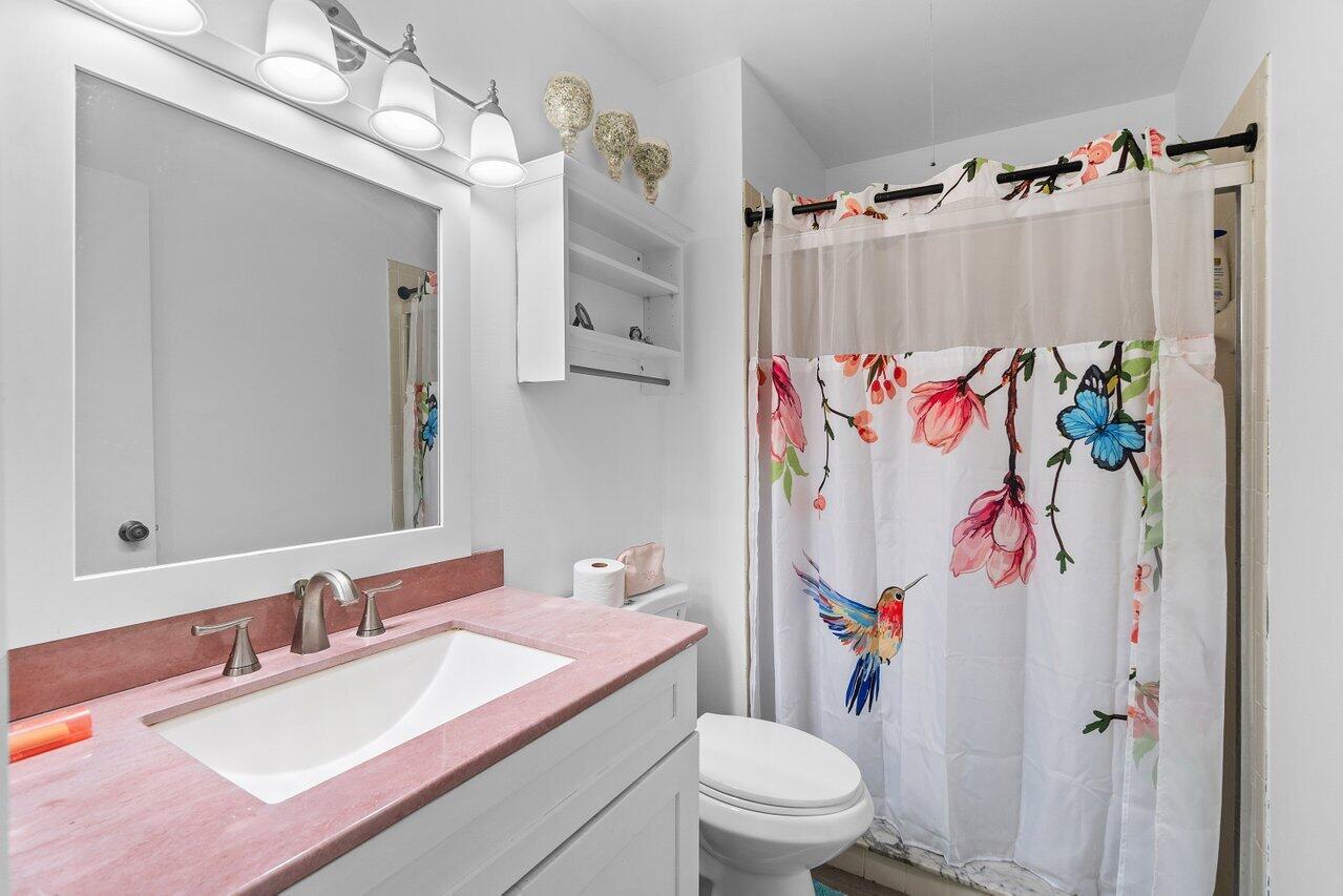 6199 Riverwalk Lane, Unit 6 Jupiter, FL 33458 - Photo 20 of 33 a bathroom with a sink vanity mirror and toilet
