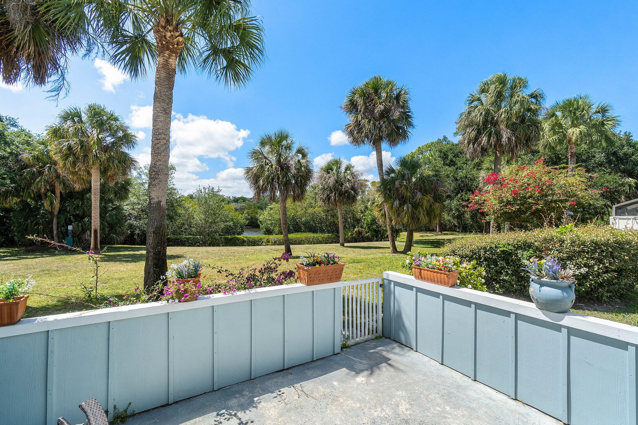6199 Riverwalk Lane, Unit 6 Jupiter, FL 33458 - Photo 25 of 33 a view of a backyard with a garden and lake view