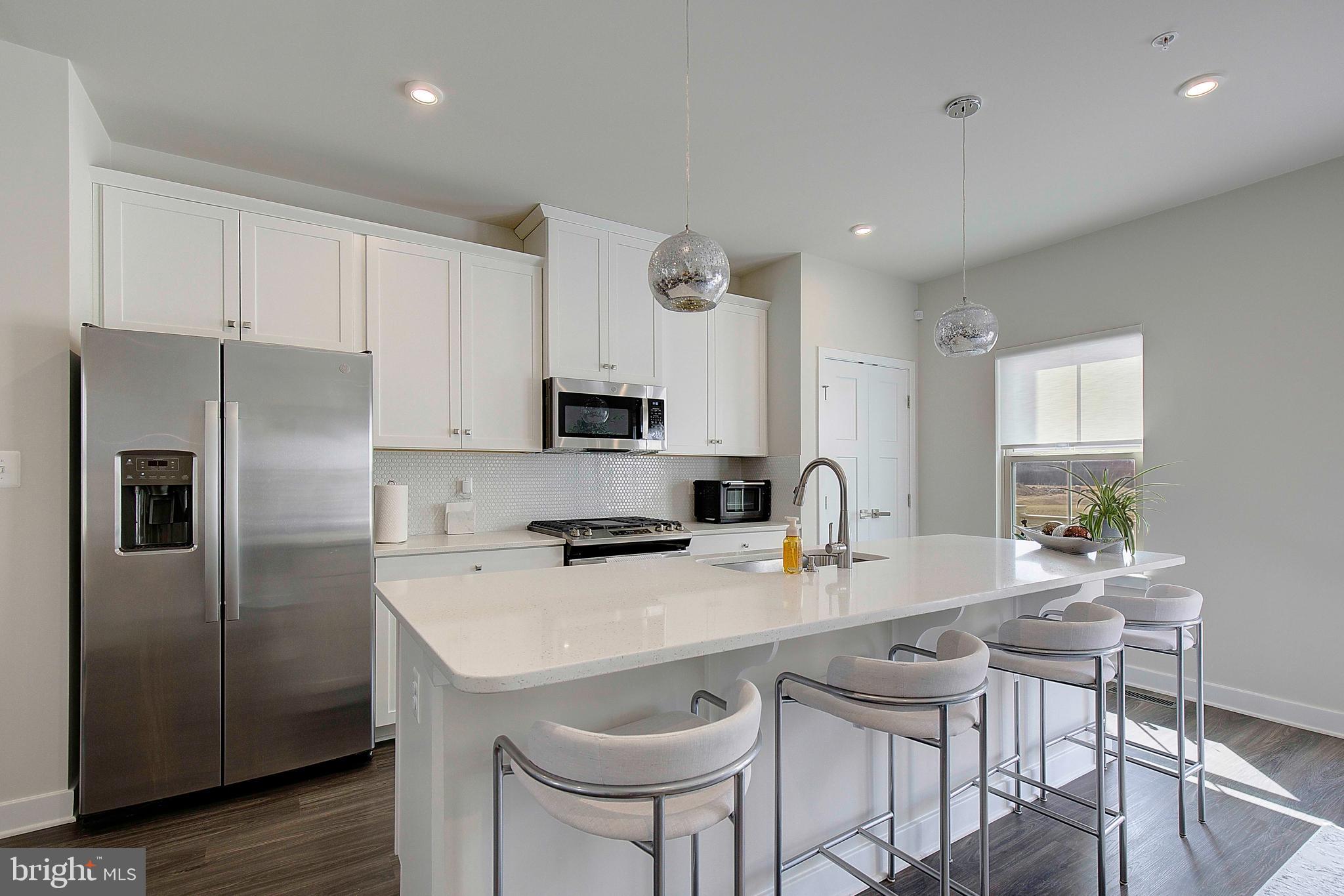 121 Swanson Creek Terrace Laurel, MD 20708 - Photo 16 of 31 a kitchen with stainless steel appliances a sink a stove a refrigerator cabinets and dining table