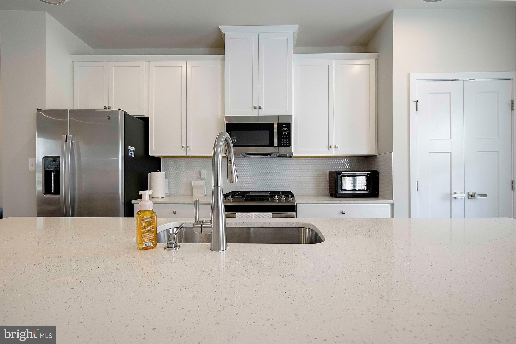 121 Swanson Creek Terrace Laurel, MD 20708 - Photo 20 of 31 a kitchen with stainless steel appliances a stove a refrigerator a sink a stove and cabinets