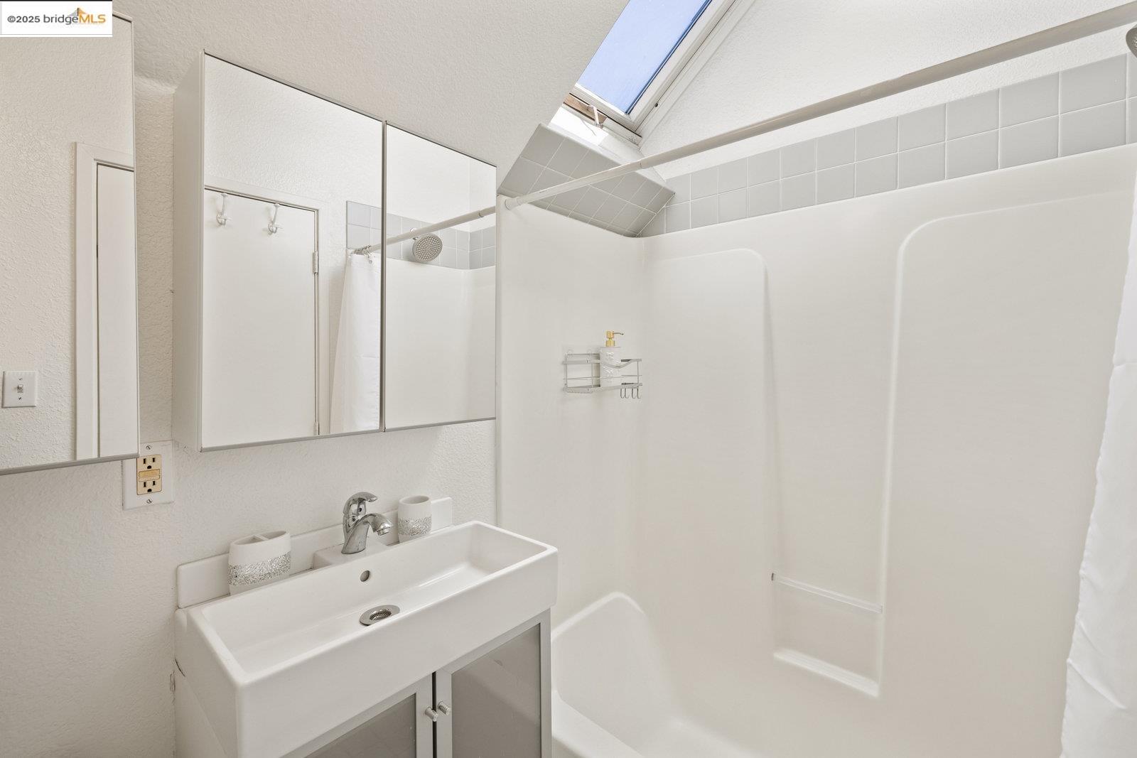 1450 Fourth Street, Unit 5 Berkeley, CA 94710 - Photo 8 of 18 a bathroom with a sink a mirror and a shower