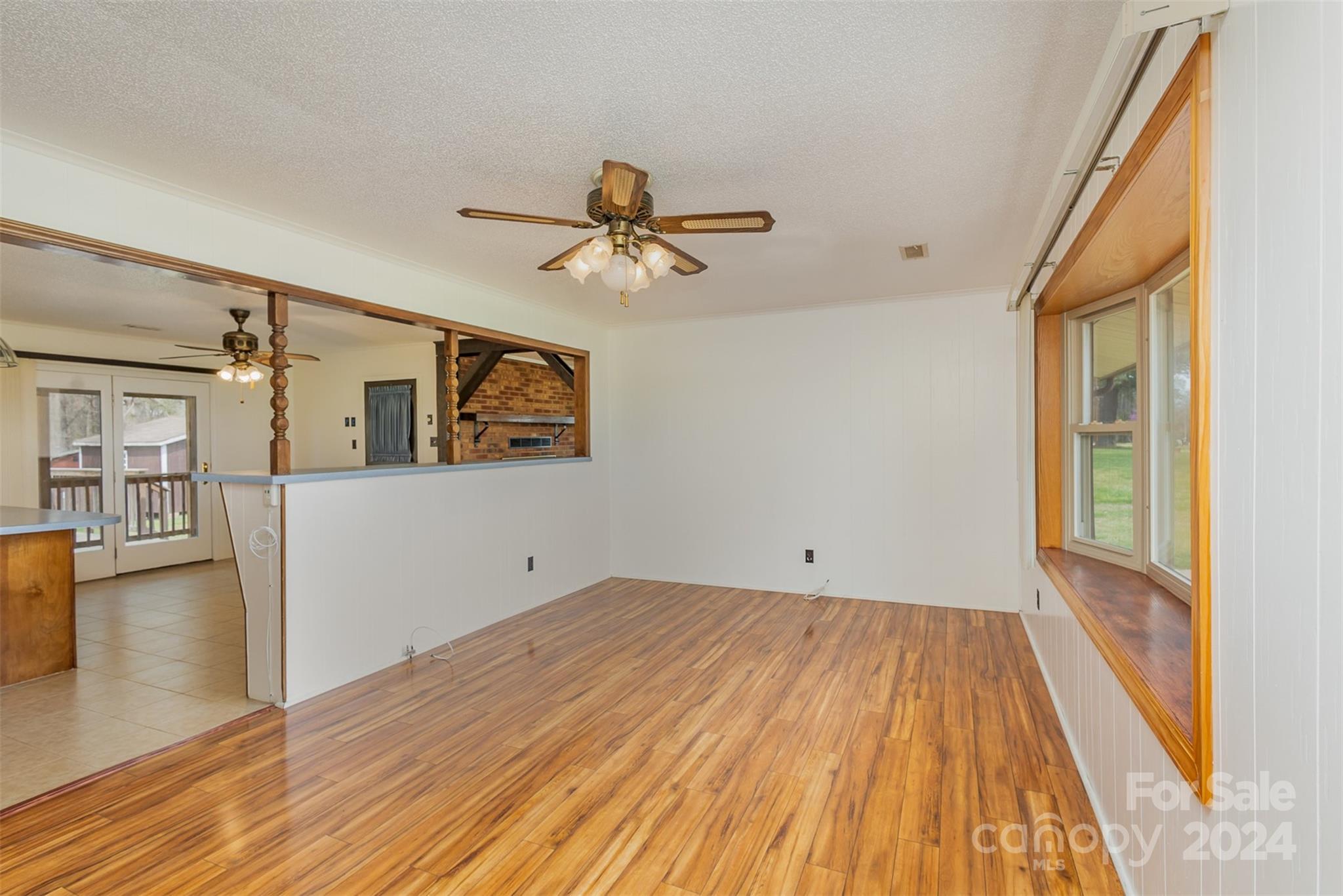 4007 Beaty Road Gastonia, NC 28056 - Photo 7 of 24 a view of a livingroom with wooden floor and a ceiling fan