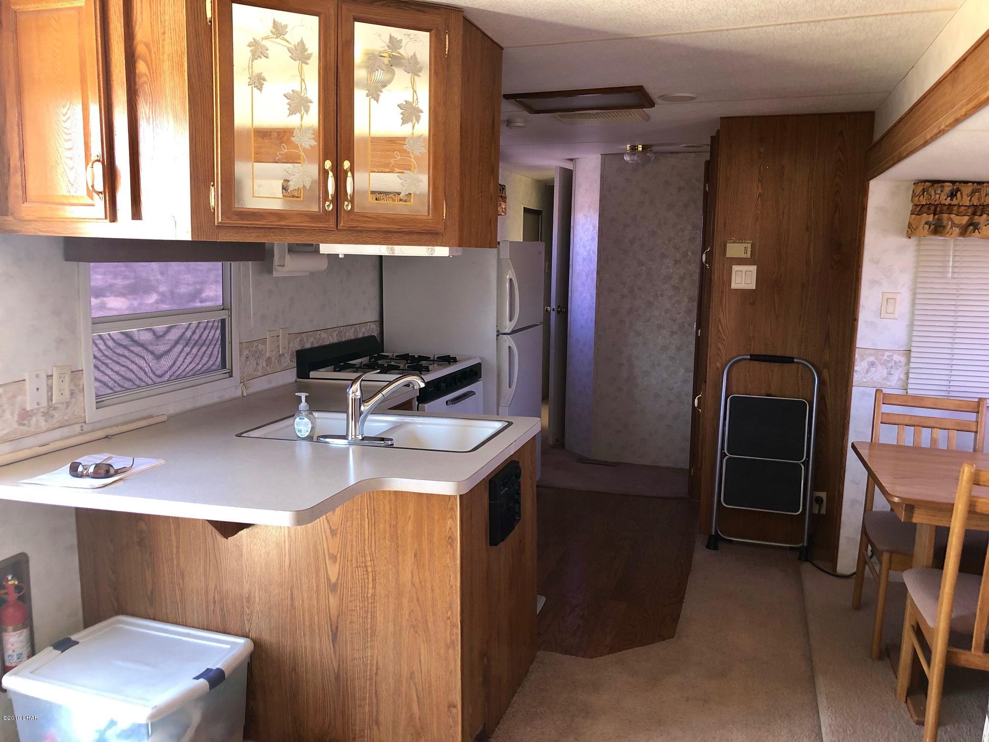 14106 Ashurst Road Yucca, AZ 86438 - Photo 2 of 17 a kitchen with stainless steel appliances granite countertop a sink stove and refrigerator