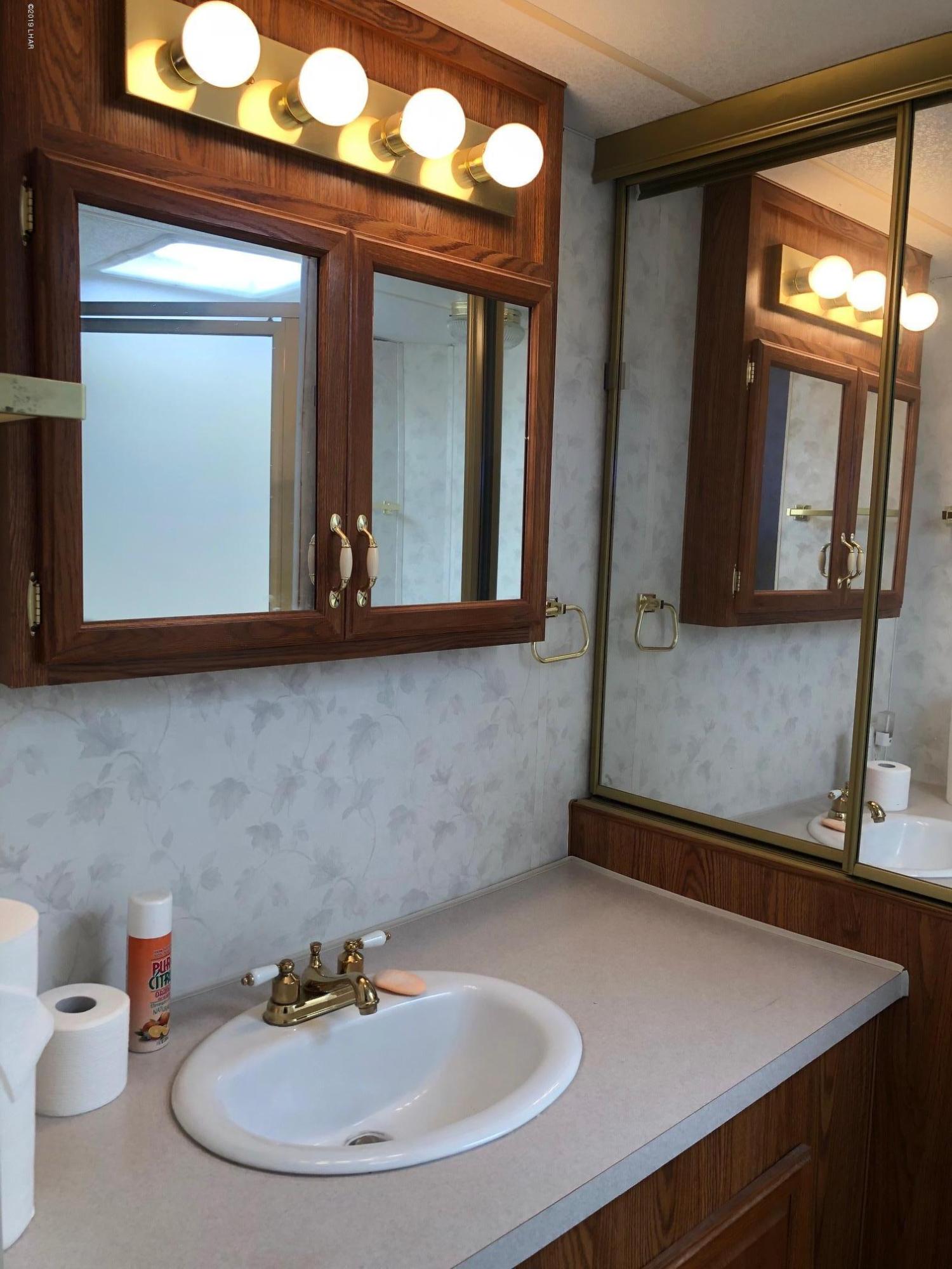 14106 Ashurst Road Yucca, AZ 86438 - Photo 4 of 17 a bathroom with a sink and a mirror